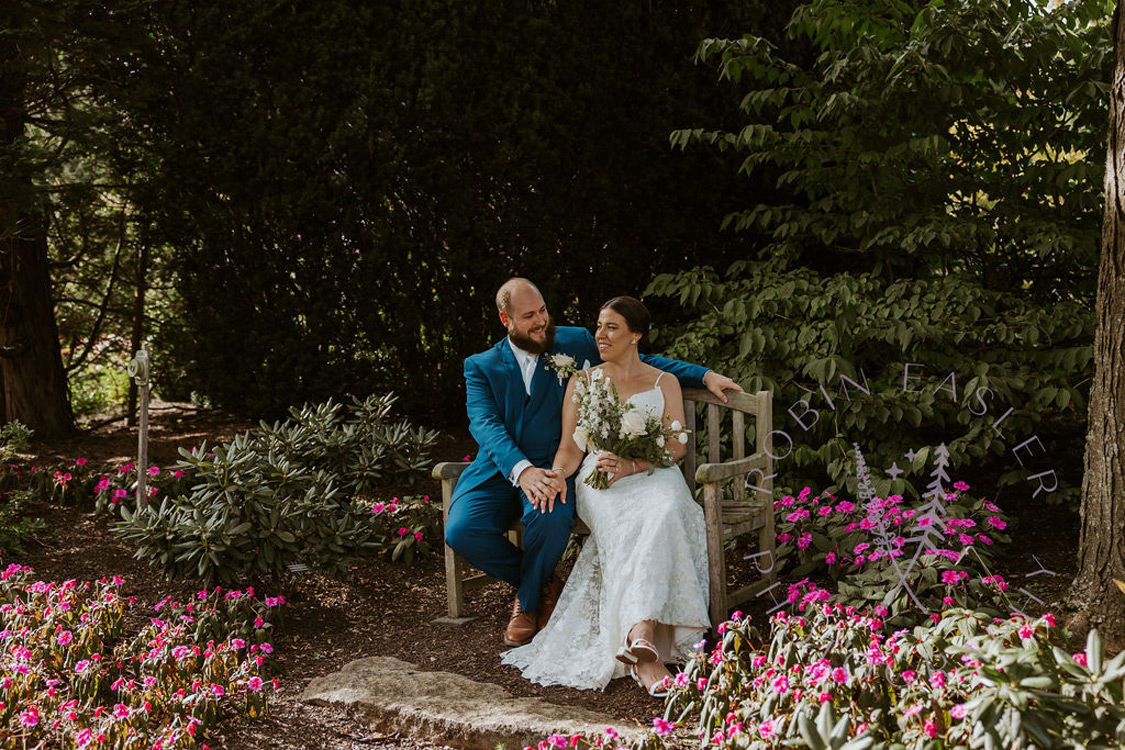 A couple sitting on a bench at The Gardens at Uncanoonuc Mountain.