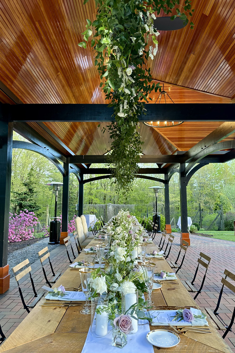 A table setting underneath the Pavilion at The Gardens at Uncanoonuc Mountain.
